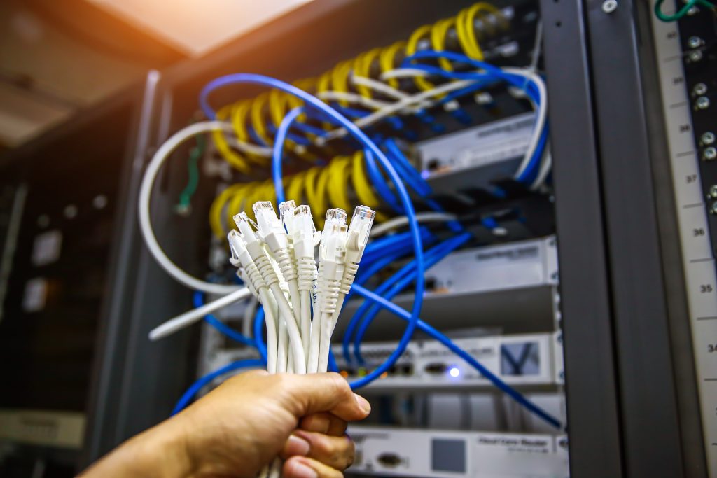 Engineer holding ethernet cables in front of server